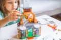 Girls, sisters play kids constructor, build house Lego Harry Potter from bricks, blocks by assembly instrustions. Children activity at home in playroom. Intelligent development of fine motor skills.